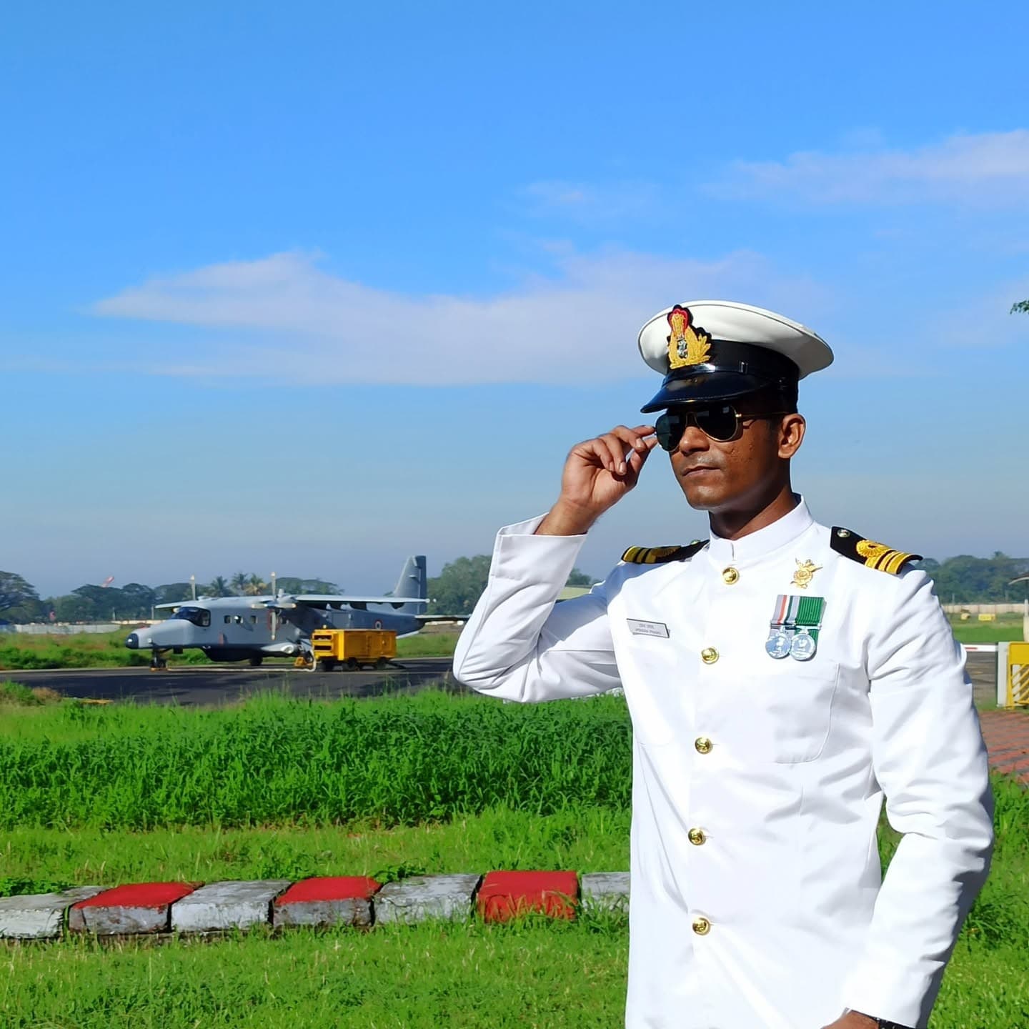 The creator in Indian Navy dress whites on the airfield — the backbone the whole journey is built on